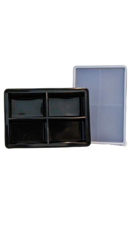 Abgebildet ist eine rechteckige, schwarze Form mit vier Fächern. Daneben steht eine durchscheinende Form in Grau. Beide Formen sind nebeneinander auf einem weißen Hintergrund platziert.